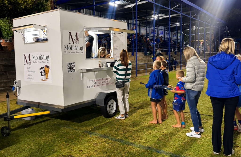 MobiMug Mobile Coffee Trailer Solutions is a stylish, fully equipped Mobile Coffee Trailer! Serving Success, One Cup at a Time. Because people don't just buy coffee... They buy the experience, the rich flavour, and the moment that comes with every cup. MobiMug Mobile Coffee Solutions is a stylish, fully equipped mobile coffee trailer serving freshly brewed Barista Coffee hot and cold, Tea, Freezos, Hot and cold Chocolate, Slush Puppy, Cold drinks, Water, Energy Drinks, Snacks, Biltong and more. We proudly serve schools, markets, festivals, weddings, corporate and private events across Gauteng — and beyond. Enjoy Premium coffee hot or cold, — all served with warmth, style, and professionalism. Homepage of MobiMug Molbile Coffee Trailer Solutions!